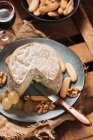Vista de perto de queijo com pão e vinho em bandeja de madeira — Fotografia de Stock