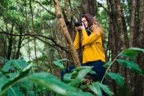 Woman taking shots in forest — Stock Photo