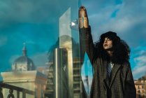 Donna attraente a caso di vetro che riflette edifici della città — Foto stock