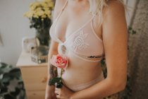 Crop unrecognizable seductive woman in lingerie with rose. — Stock Photo