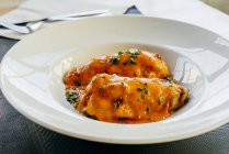 Peperoni ripieni con salsa su piatto bianco — Foto stock