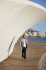 Uomo d'affari che cammina nel vicolo oltre al mare — Foto stock