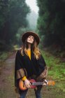 Чарівна жінка позує з укулелею на сільській дорозі в лісі — стокове фото