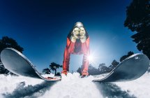Человек, тренирующийся кататься на лыжах против ясного голубого неба — стоковое фото