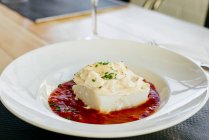 Close up view of cod with cream and tomato sauce in plate — Stock Photo
