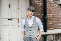 Young man in vintage cap posing on stairs — Stock Photo