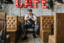 Hombre de ensueño sentado en la cafetería vintage - foto de stock