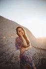 Tender brunette girl in dress posing on rocky terrain — Stock Photo