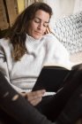 Femme brune couchée dans un hamac avec livre — Photo de stock