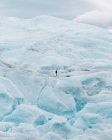Vista lejana del turista parado en la colina nevada - foto de stock