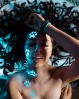 Mulher com impressões fluorescentes da pata no rosto — Fotografia de Stock