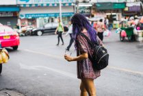 Pretty young woman with purple hair walking on street — Stock Photo
