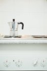 Metallic coffee pot heating on stove in kitchen at home. — Stock Photo
