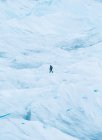 Vista lateral del turista caminando sobre una colina nevada - foto de stock