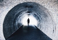 Silueta caminando en túnel de azulejos . - foto de stock