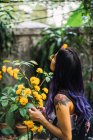 Вид сбоку женщины, трогающей желтый цветок — стоковое фото