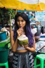 Asiatin trinkt mit Stroh aus Kokosnuss — Stockfoto