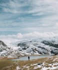 Wanderer steht über See in Hügeln im Hintergrund — Stockfoto