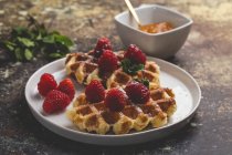 Close up view of waffle with cream raspberries and chocolate strawberries. — Stock Photo