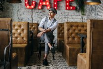 Мечтающий человек в винтажной одежде сидит в кафе — стоковое фото