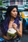 Молода жінка з кокосом на вуличній сцені — стокове фото