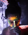Retrato de mujer con pintura luminosa y pluma - foto de stock