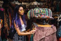 Mujer bonita con el pelo morado posando en tienda de ropa - foto de stock