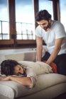 Uomo massaggiare donna in allenatore a casa — Foto stock