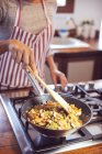 Mid section of woman cooking on stove at kitchen — Stock Photo