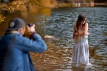Fotógrafo atirando mulher em vestido branco — Fotografia de Stock