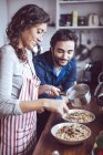 Junges Paar kocht Essen in Küche — Stockfoto