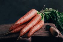 Свіжа морква і ніж на дерев'яній обробній дошці — стокове фото
