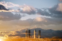 Doppelbelichtungsaufnahme von Wolkenkratzern und sonnenbeschienener Wolkenlandschaft — Stockfoto