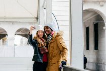 Cheerful couple taking selfie on rink — Stock Photo