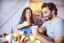 Feliz jovem casal tomando café da manhã juntos — Fotografia de Stock