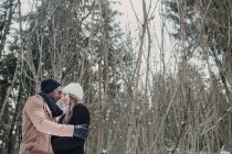 Багаторасова пара зв'язується в зимовому лісі — стокове фото