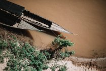 De cima tiro de dois barcos de madeira flutuando no rio sujo perto da costa . — Fotografia de Stock