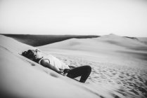 Красива жінка лежить на піску і насолоджується сонцем . — стокове фото