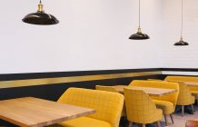 Interior view of tables and yellow chairs in cafe — Stock Photo