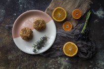 Directamente encima de la vista de falafel en el plato y rodajas de naranja en la mesa - foto de stock