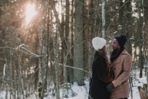 Casal multirracial ligação na floresta de inverno no dia ensolarado — Fotografia de Stock