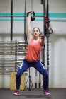 Mulher desportiva treinando com haltere no ginásio — Fotografia de Stock