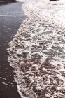 Скелі в серфінгу морських хвиль на березі в підсумку — стокове фото