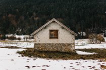 Small house amid winter countryside landscape — Stock Photo