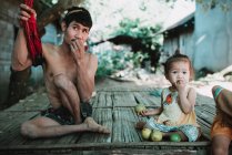 Nong khiaw, laos: lokaler Mann und süßes Mädchen mit Früchten — Stockfoto