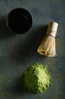 Directly above view of matcha tea, bamboo whisk an bowl on table — Stock Photo