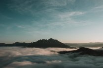 Облака, плывущие по горным вершинам в солнечный день — стоковое фото