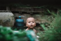 LAOS, 4000 ISLAS ÁREA: Niño encantador sentado en el suelo y mirando hacia fuera - foto de stock