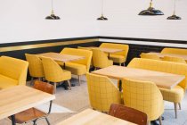 Mesas vazias e cadeiras amarelas na cafetaria . — Fotografia de Stock