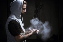 Uomo mani battenti con polvere di gesso su sfondo scuro — Foto stock